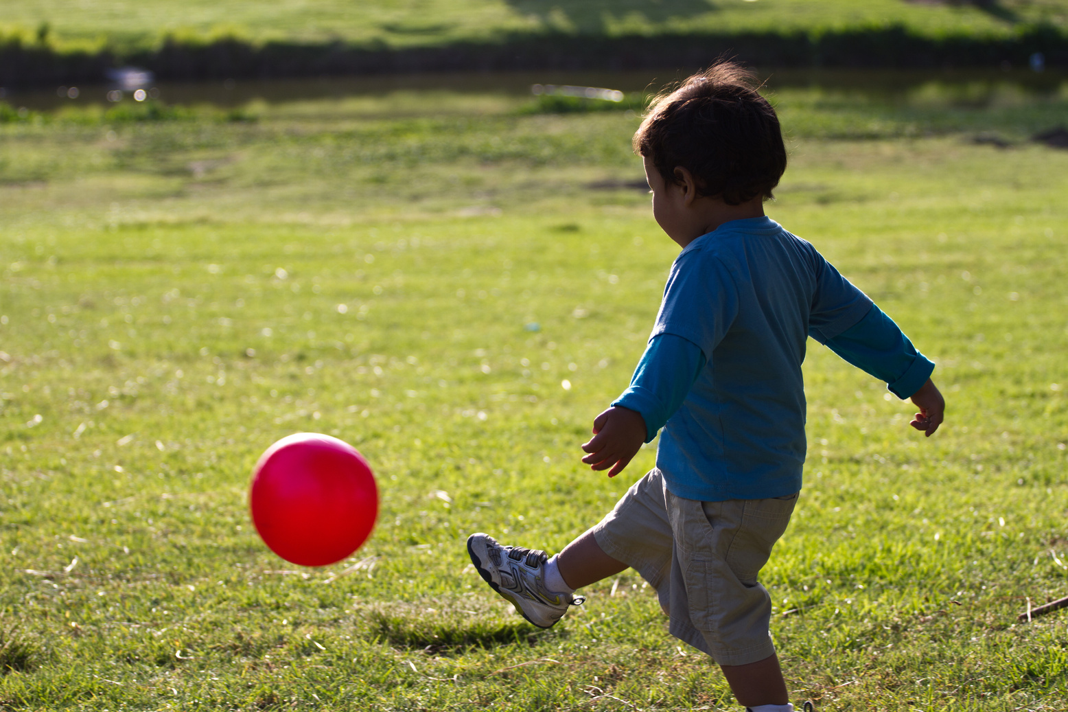 Toddler child running and kicking soccer ball